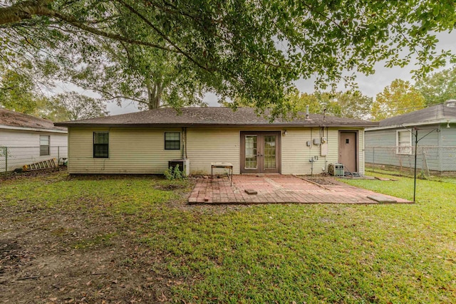 back of property featuring a lawn, french doors, and a patio