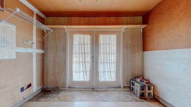 entryway featuring wood walls and french doors