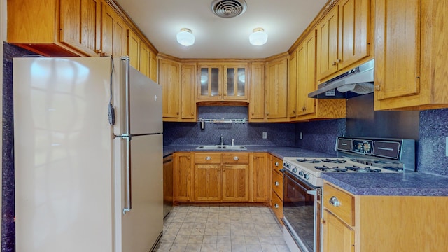 kitchen with dishwasher, backsplash, white refrigerator, sink, and range