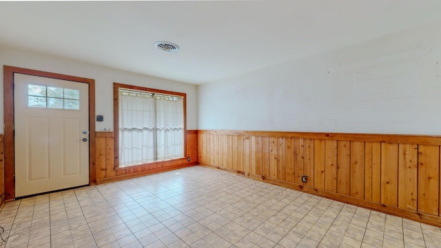 foyer entrance featuring wood walls