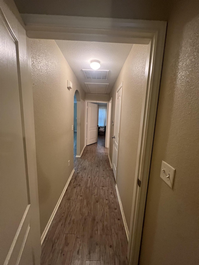 hall featuring dark hardwood / wood-style floors and a textured ceiling