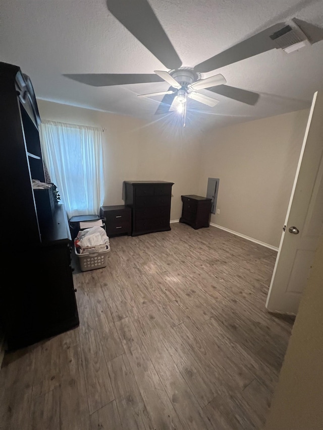 unfurnished bedroom featuring a textured ceiling, dark hardwood / wood-style floors, and ceiling fan