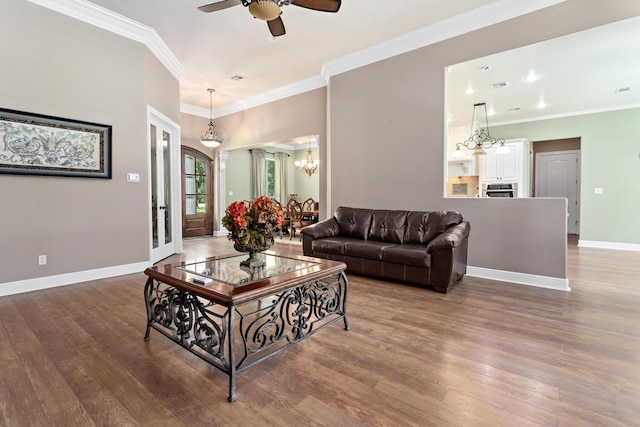 living room with ceiling fan with notable chandelier, dark hardwood / wood-style floors, and crown molding