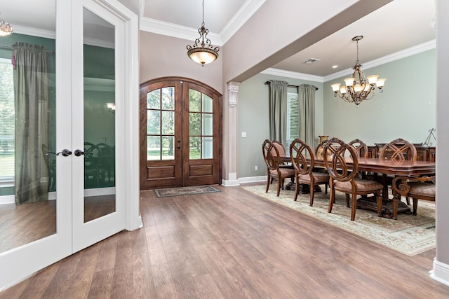 foyer entrance featuring wood-type flooring, ornamental molding, and french doors