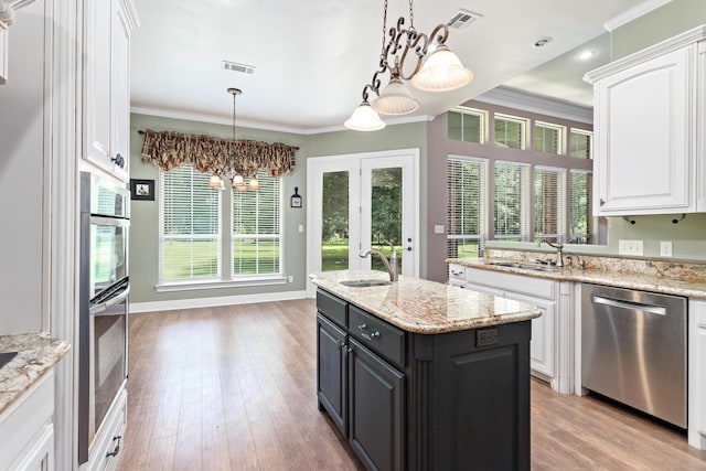 kitchen with dishwasher, a kitchen island, sink, ornamental molding, and white cabinets