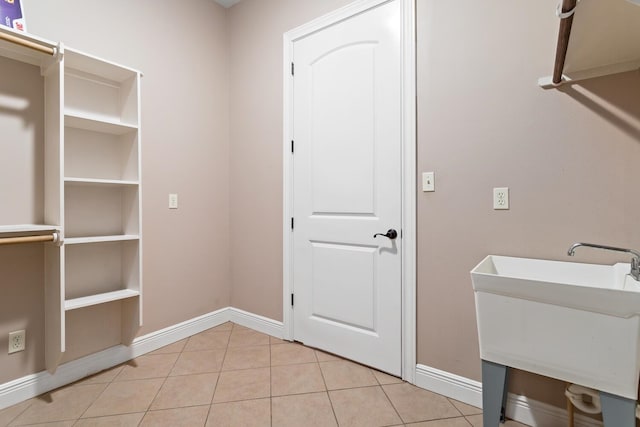 laundry room featuring light tile patterned floors and sink