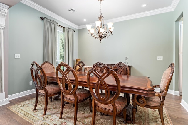 dining area with an inviting chandelier, ornamental molding, and wood-type flooring