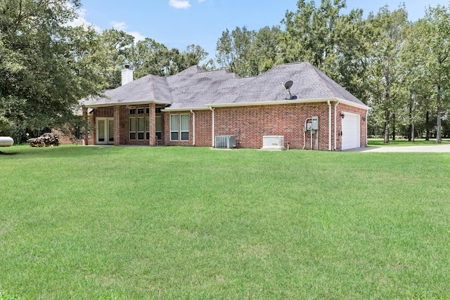 back of house featuring a lawn, central air condition unit, and a garage