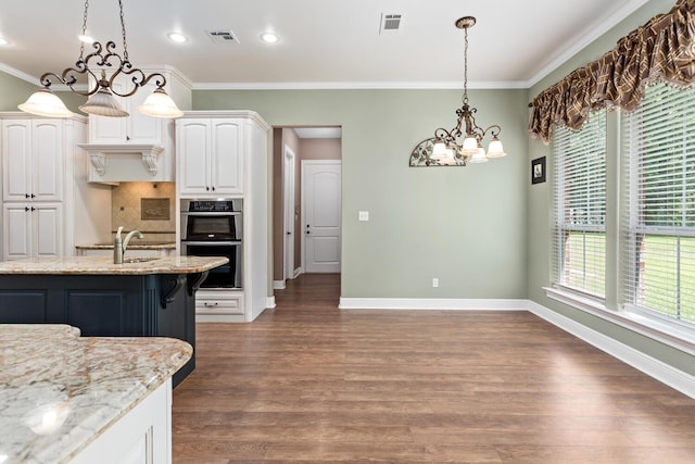 kitchen featuring light stone countertops, white cabinets, decorative light fixtures, double oven, and decorative backsplash