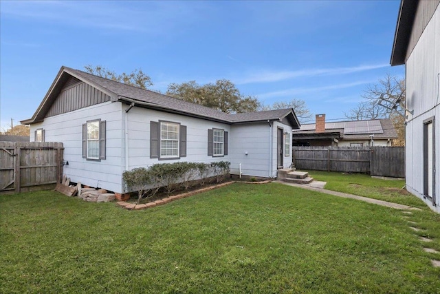 rear view of property featuring a lawn