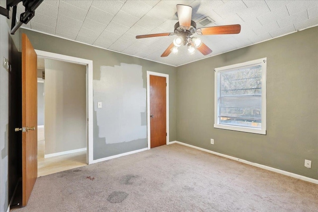 unfurnished bedroom featuring light colored carpet and ceiling fan