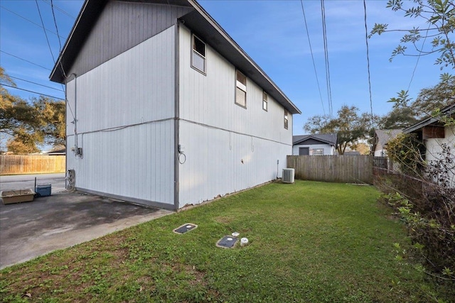 view of side of property with central AC unit, a lawn, and a patio area