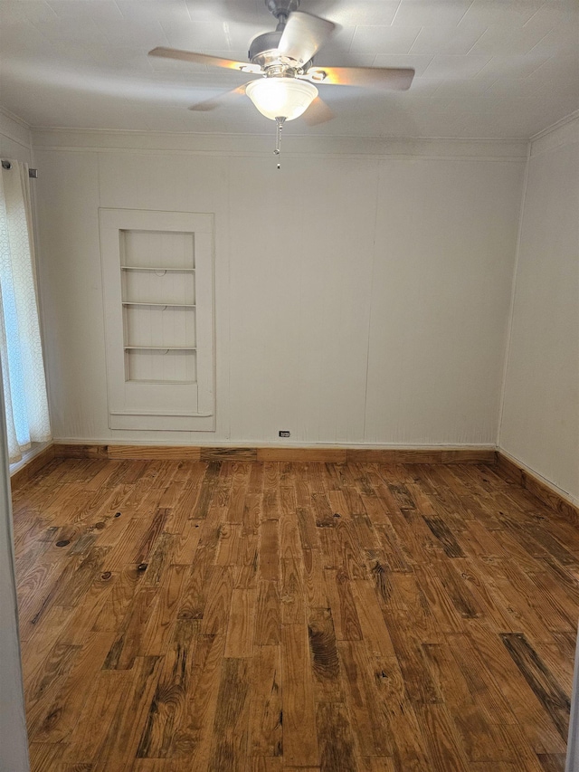 unfurnished room featuring built in shelves, ceiling fan, and hardwood / wood-style floors