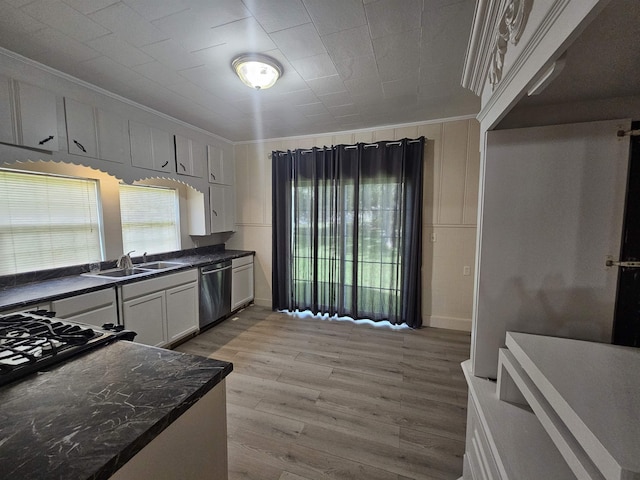 kitchen featuring stainless steel dishwasher, plenty of natural light, white cabinets, and ornamental molding