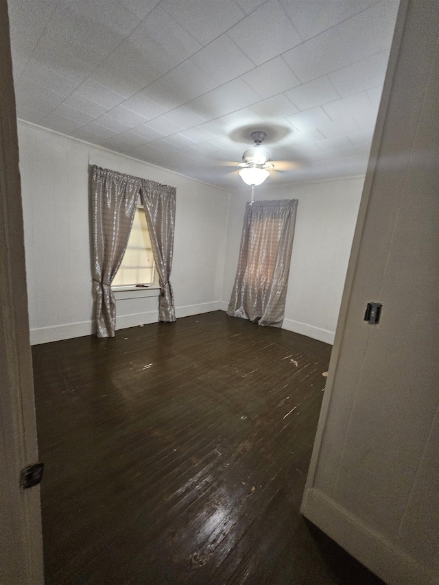 spare room featuring ceiling fan and dark wood-type flooring