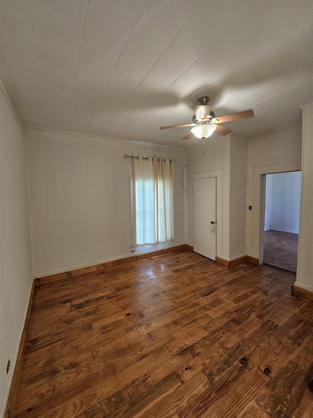 empty room with dark hardwood / wood-style floors, ceiling fan, and crown molding