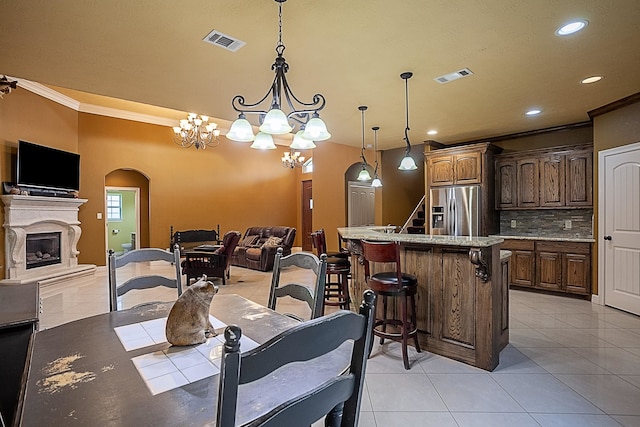 3812 Debbie Ave, Groves, TX 77619 - dining space with light tile patterned flooring, crown molding, recessed lighting, arched walkways, and a chandelier