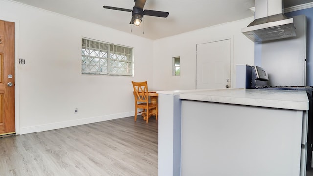 3875 Bowen Dr, Beaumont, TX 77708 - kitchen featuring wall chimney range hood, light wood-type flooring, ceiling fan, and light countertops