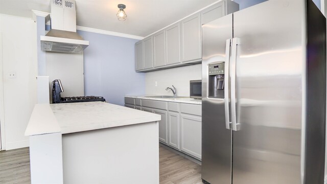 3875 Bowen Dr, Beaumont, TX 77708 - kitchen with stainless steel appliances, exhaust hood, gray cabinets, light wood-type flooring, and light countertops