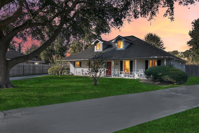 view of front of property featuring covered porch and a lawn