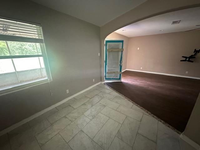 320 Meadow Dr, Bridge City, TX 77611 - unfurnished room with arched walkways, baseboards, and marble look tile flooring