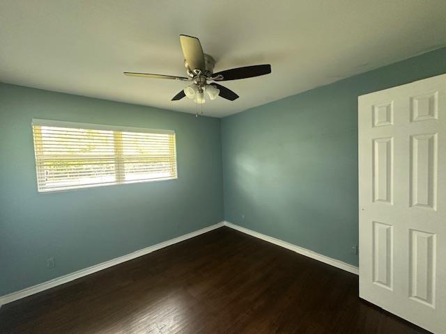 320 Meadow Dr, Bridge City, TX 77611 - unfurnished room with baseboards, dark wood-type flooring, and ceiling fan