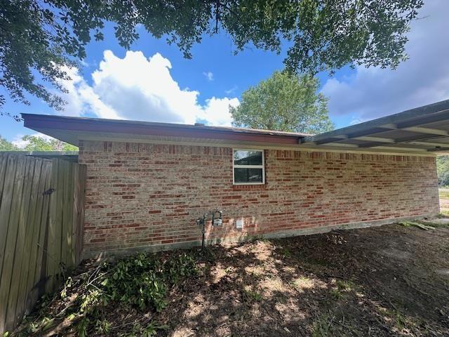 320 Meadow Dr, Bridge City, TX 77611 - view of home's exterior with brick siding and fence