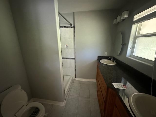 320 Meadow Dr, Bridge City, TX 77611 - bathroom with a tile shower, baseboards, toilet, and vanity