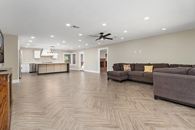 living area with baseboards, a ceiling fan, and recessed lighting