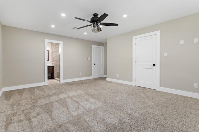 unfurnished bedroom featuring baseboards, recessed lighting, carpet flooring, ensuite bath, and a ceiling fan