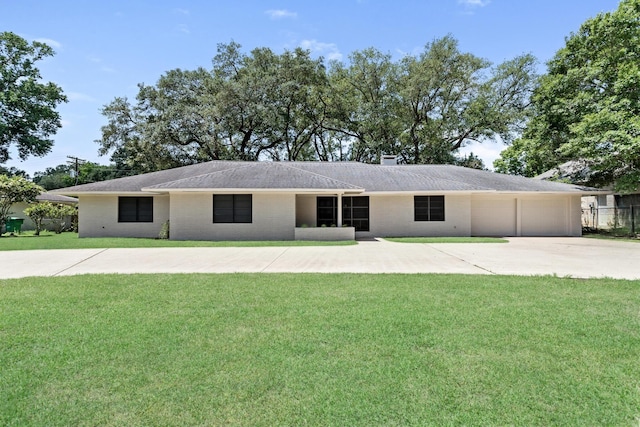 ranch-style house featuring a front lawn, an attached garage, concrete driveway, and brick siding