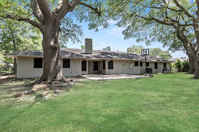 rear view of property with a chimney, a patio, and brick siding