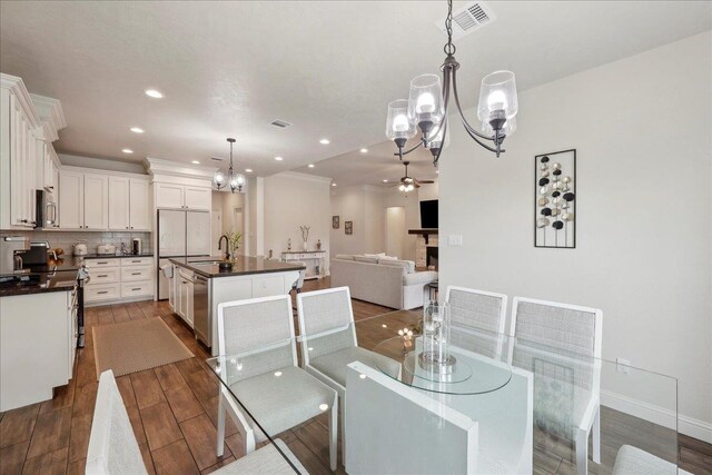 9270 Pampas St, Beaumont, TX 77713 - dining area with recessed lighting, ceiling fan with notable chandelier, baseboards, visible vents, and dark wood-type flooring