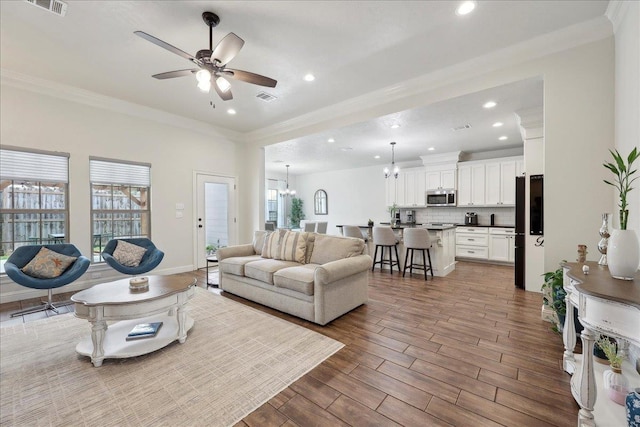9270 Pampas St, Beaumont, TX 77713 - living area featuring visible vents, recessed lighting, ornamental molding, and ceiling fan with notable chandelier
