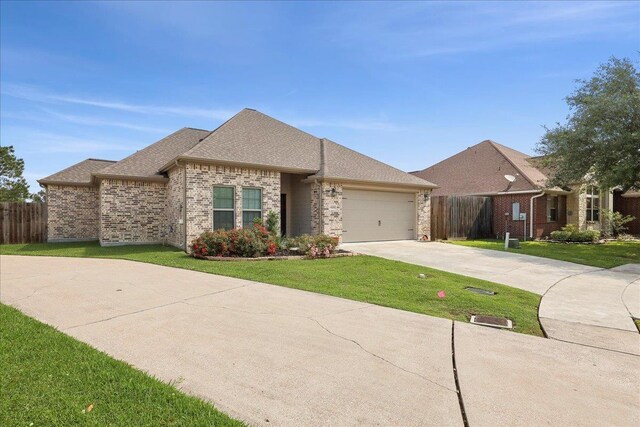 9270 Pampas St, Beaumont, TX 77713 - view of front facade with brick siding, fence, concrete driveway, and an attached garage