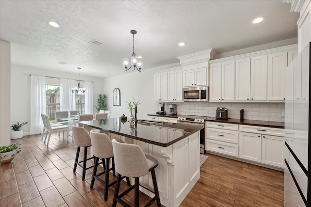 9270 Pampas St, Beaumont, TX 77713 - kitchen featuring tasteful backsplash, dark countertops, stainless steel appliances, visible vents, and an inviting chandelier