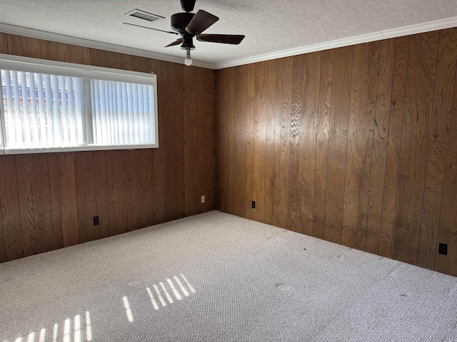 spare room featuring ceiling fan, visible vents, carpet floors, and a textured ceiling