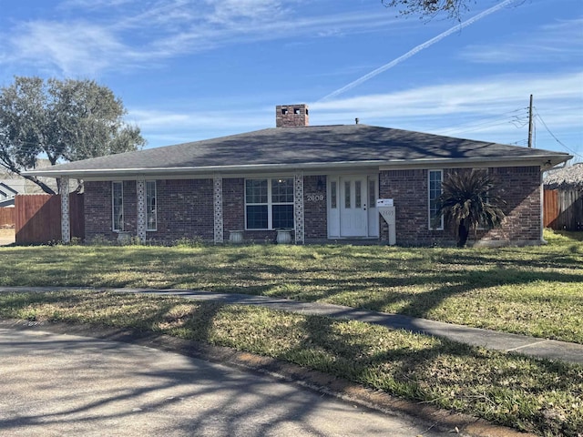 single story home featuring fence, roof with shingles, a front yard, brick siding, and a chimney