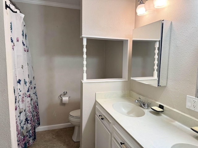 full bath with crown molding, baseboards, toilet, double vanity, and a sink