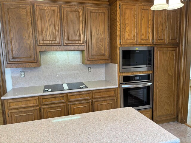 1470 Sheridan Ln, Beaumont, TX 77706 - kitchen featuring oven, black electric stovetop, built in microwave, and brown cabinetry