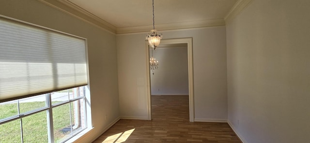 interior space with a chandelier, wood finished floors, baseboards, and ornamental molding