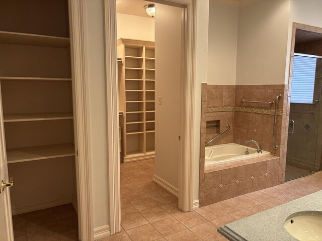 1470 Sheridan Ln, Beaumont, TX 77706 - full bathroom with a walk in closet, tile patterned flooring, a bath, vanity, and tiled shower