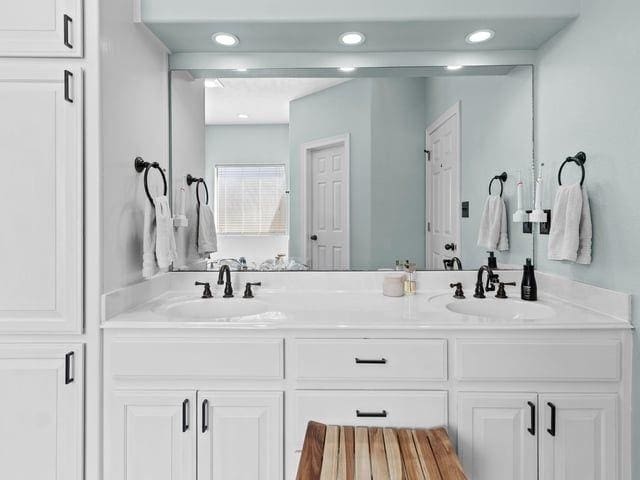 bathroom with double vanity, a sink, and recessed lighting