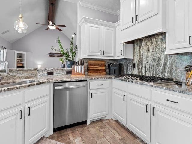 kitchen with light wood-style floors, decorative backsplash, stainless steel appliances, a sink, and ceiling fan
