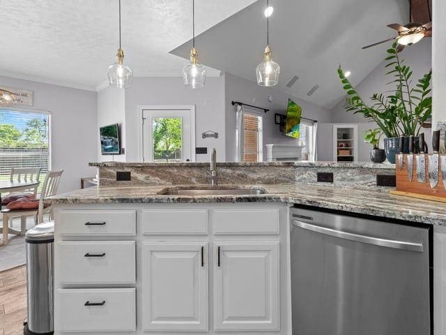 kitchen with ceiling fan, white cabinetry, light stone counters, dishwasher, and a sink