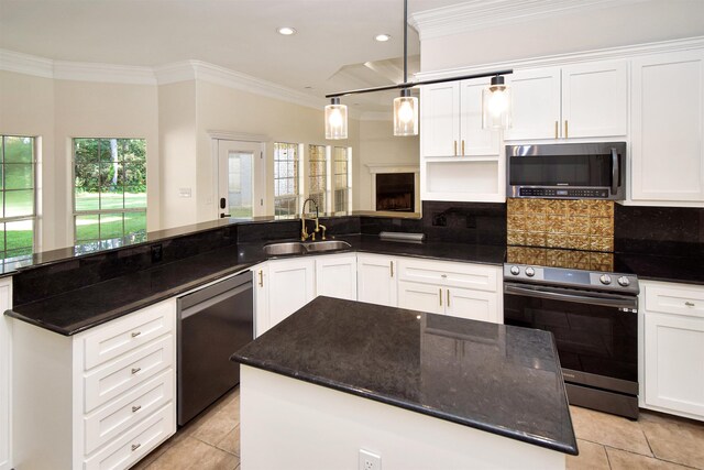 kitchen with a center island, sink, decorative light fixtures, white cabinets, and appliances with stainless steel finishes