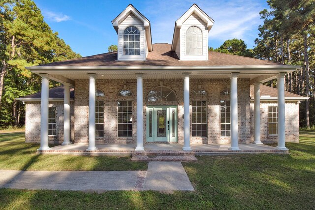 view of front of home with a porch and a front yard