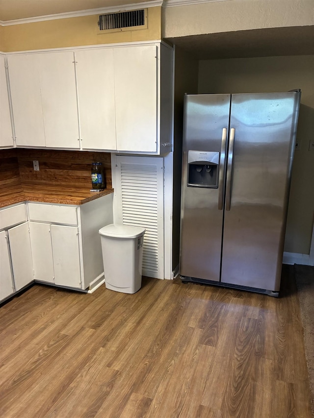 2515 Glenwood Dr, Port Arthur, TX 77642 - kitchen featuring stainless steel fridge, wood finished floors, white cabinetry, and crown molding