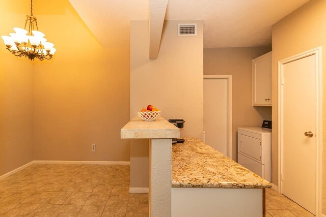 1620 Wellington Pl, Beaumont, TX 77706 - kitchen with washer / clothes dryer, white cabinetry, a chandelier, decorative light fixtures, and light tile patterned floors