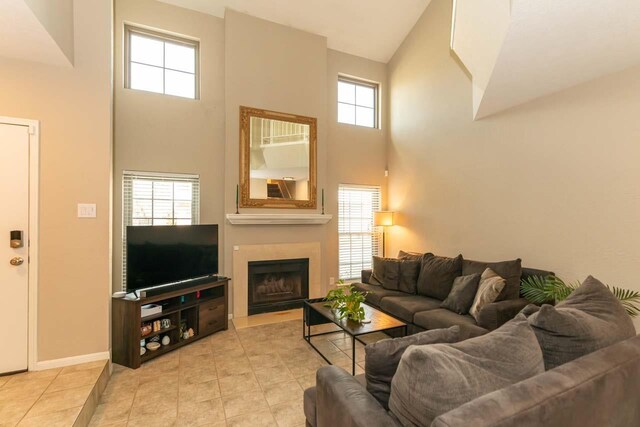 1620 Wellington Pl, Beaumont, TX 77706 - living area featuring a high ceiling, a fireplace, healthy amount of natural light, tile patterned flooring, and baseboards